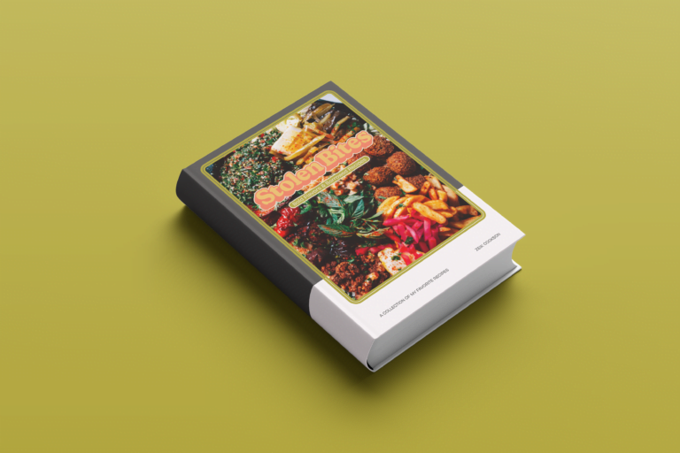 A cookbook, called "Stolen Bites", design mockup with a colorful cover featuring various street food dishes, displayed on a yellow background.